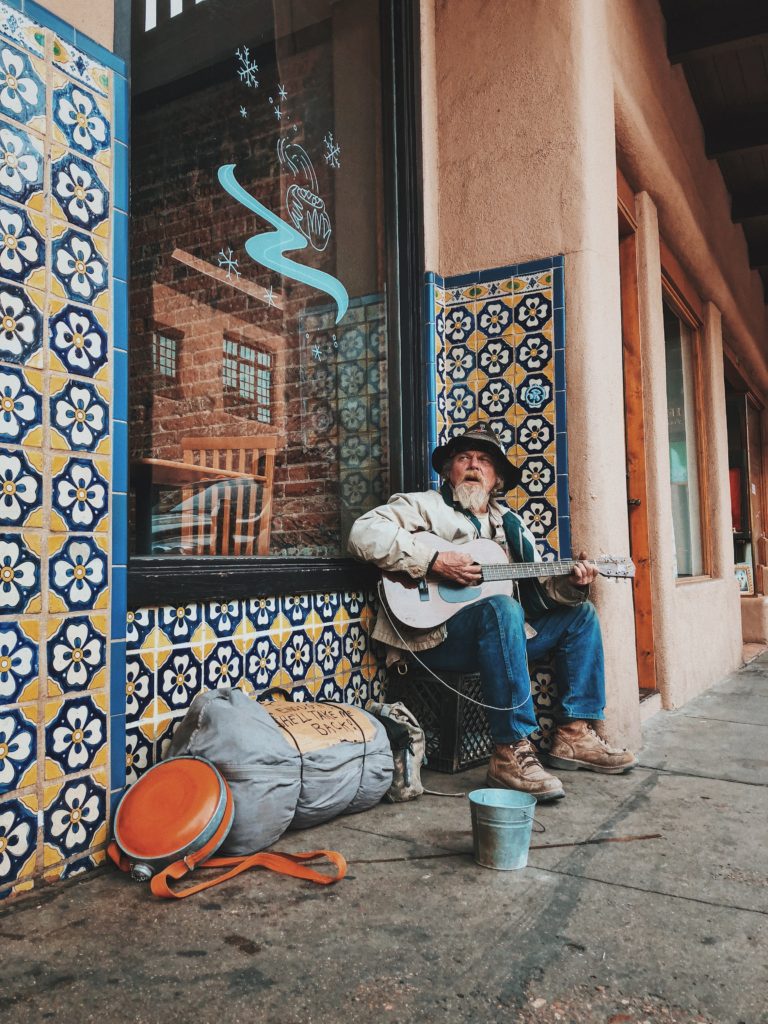 unemployed man playing guitar on the street